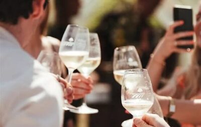 Backs of people holding wine glasses up