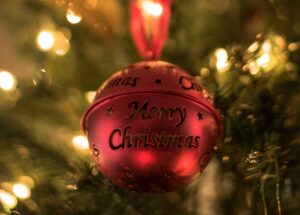 Red Christmas bauble on a tree with Merry Christmas on it. For a round up of Free & Affordable Christmas Events In Kent 2024