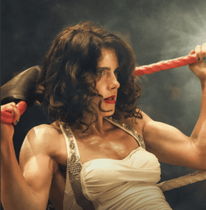 Woman with black hair and in a white strapped top leaning against boxing ring ropes for New film releases and Queen of the Ring from Vertigo Releasing