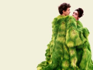 Two people in green mottled large coats facing each other with the woman looking towards the camera. For new film releases for cinemas in Kent and Ackroyd & Harvey- The Art of Activism from Tull Stories 
