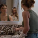 A woman looking in the mirror with a reflection of a woman behind her. For new film Housemaid from Lionsgate UK