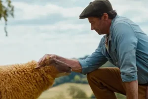 A man kneeling by a sheep for the New Films in Kent Guide and The Sheep Detectives - May 2026