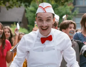 Man in white catering uniform with a red bow tie smiling in front of a group of children for New Film Releases in Kent guide and Ice Cream Man in cinemas from 7th August 2026