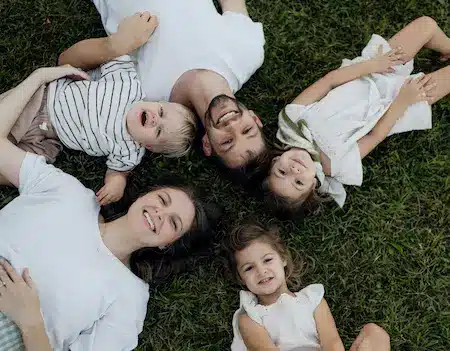 Two adults and three children lying on the grass, for things to do with kids in Kent
